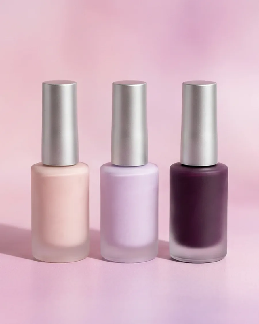 Three gentle HEMA-free gel polish bottles in nude, lilac and aubergine on a soft pink-lilac background